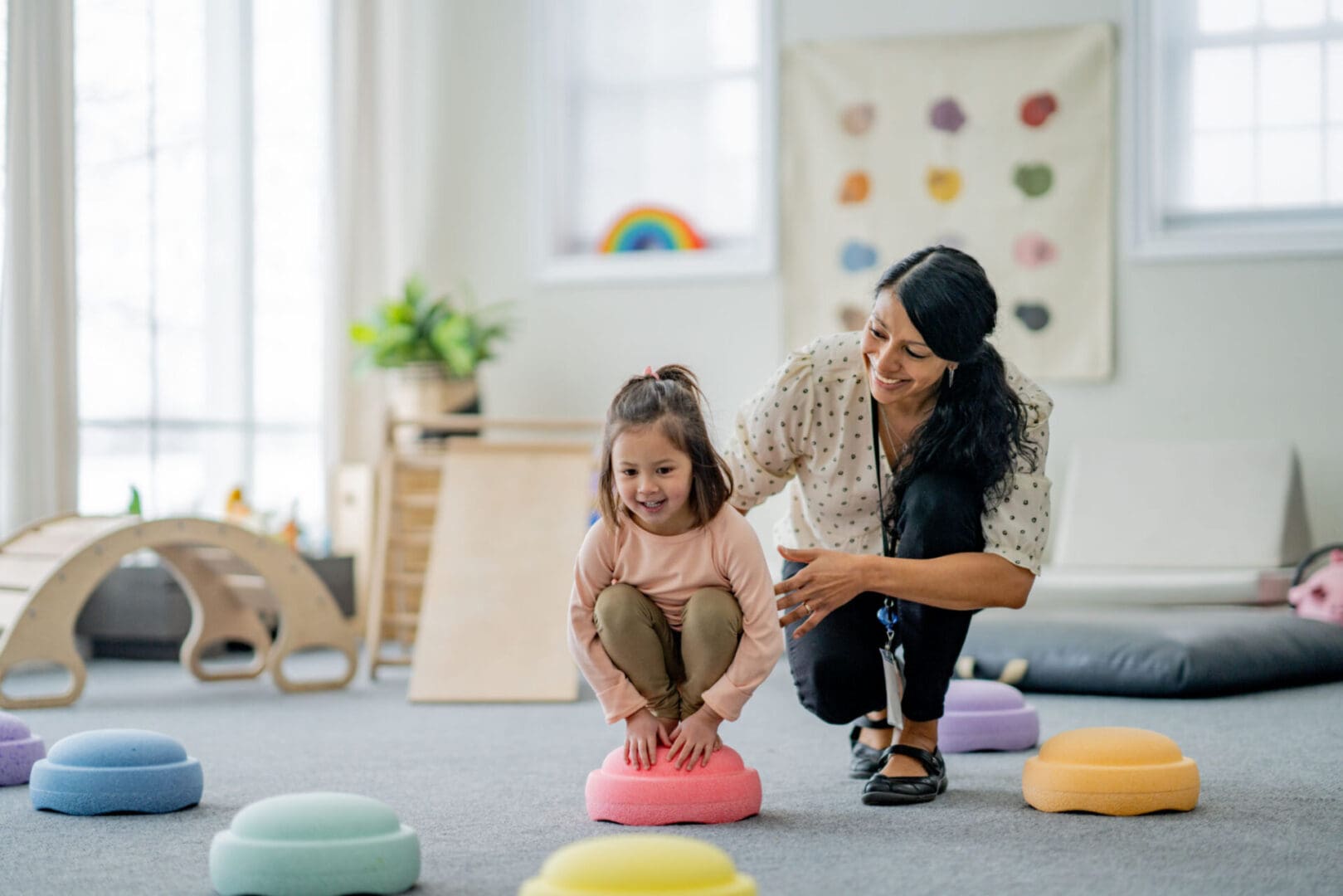 Child and adult playing in a classroom.