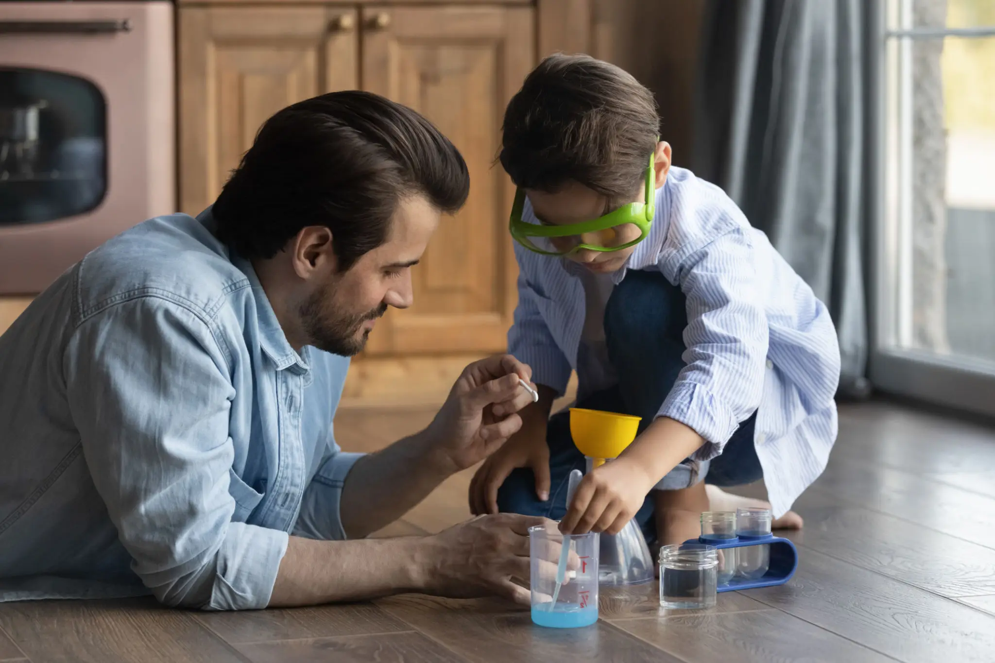 Father and son building a wooden project together indoors.